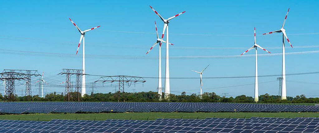 Solaranlage und Windräder in der Nähe einer Stromleitung