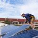 Techniker bei der Installation einer Solaranlage auf einem Hausdach zur Förderung der Solarenergie-Nutzung