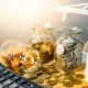 Symbolisches Geld neben einem Taschenrechner und modernen, energieeffizienten Gebäude