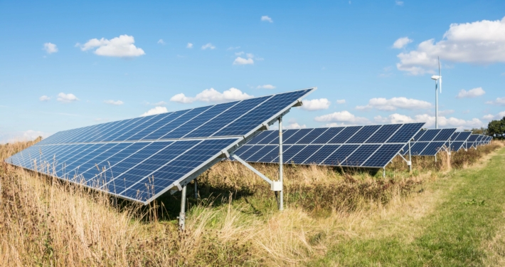 Solaranlagen und Windrad als Symbol für die fortschreitende Energiewende in Deutschland 2023