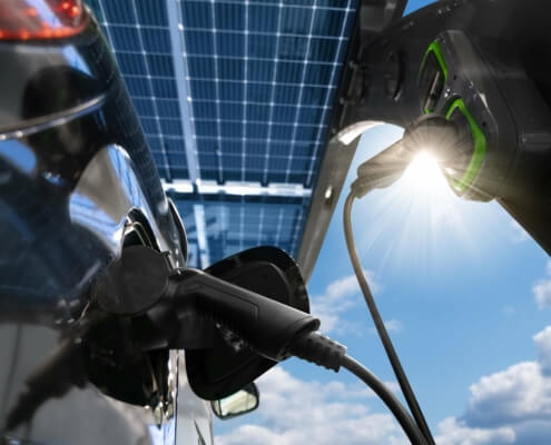 Elektroauto wird an Solar-betriebene Wallbox geladen, unterstützt durch KfW 442 Förderprogramm für 2024