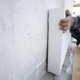 Handwerker installiert Wärmedämmung an Gebäudewand zur Energieeffizienz-Steigerung