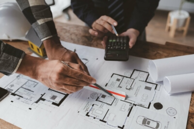Architekten und Energieberater diskutieren Baupläne für ein nachhaltiges Bauprojekt