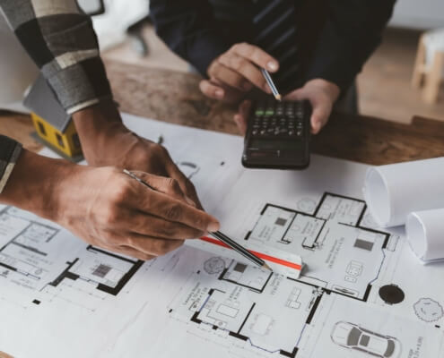 Architekten und Energieberater diskutieren Baupläne für ein nachhaltiges Bauprojekt