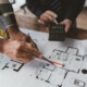 Architekten und Energieberater diskutieren Baupläne für ein nachhaltiges Bauprojekt