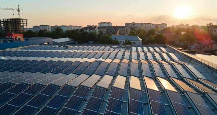 Solarzellen auf einem Dach in einer Stadt bei Sonnenaufgang, symbolisierend den Photovoltaik-Zubau in Baden-Württemberg im ersten Halbjahr 2024