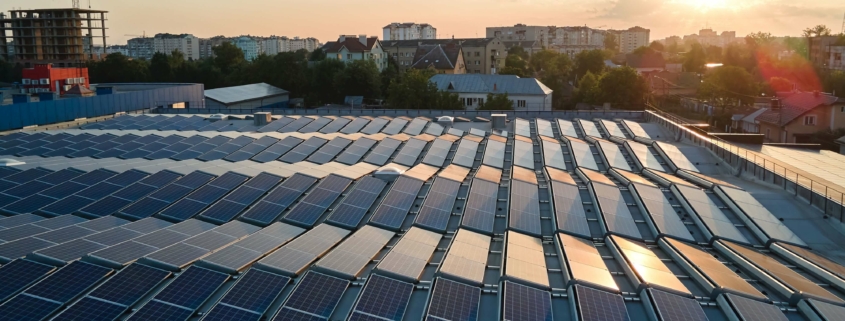 Solarzellen auf einem Dach in einer Stadt bei Sonnenaufgang, symbolisierend den Photovoltaik-Zubau in Baden-Württemberg im ersten Halbjahr 2024