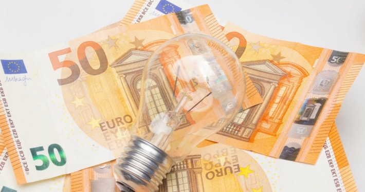 Glühbirne auf 50-Euro-Scheinen symbolisiert Kürzung der Fördermittel für Energieberatungen