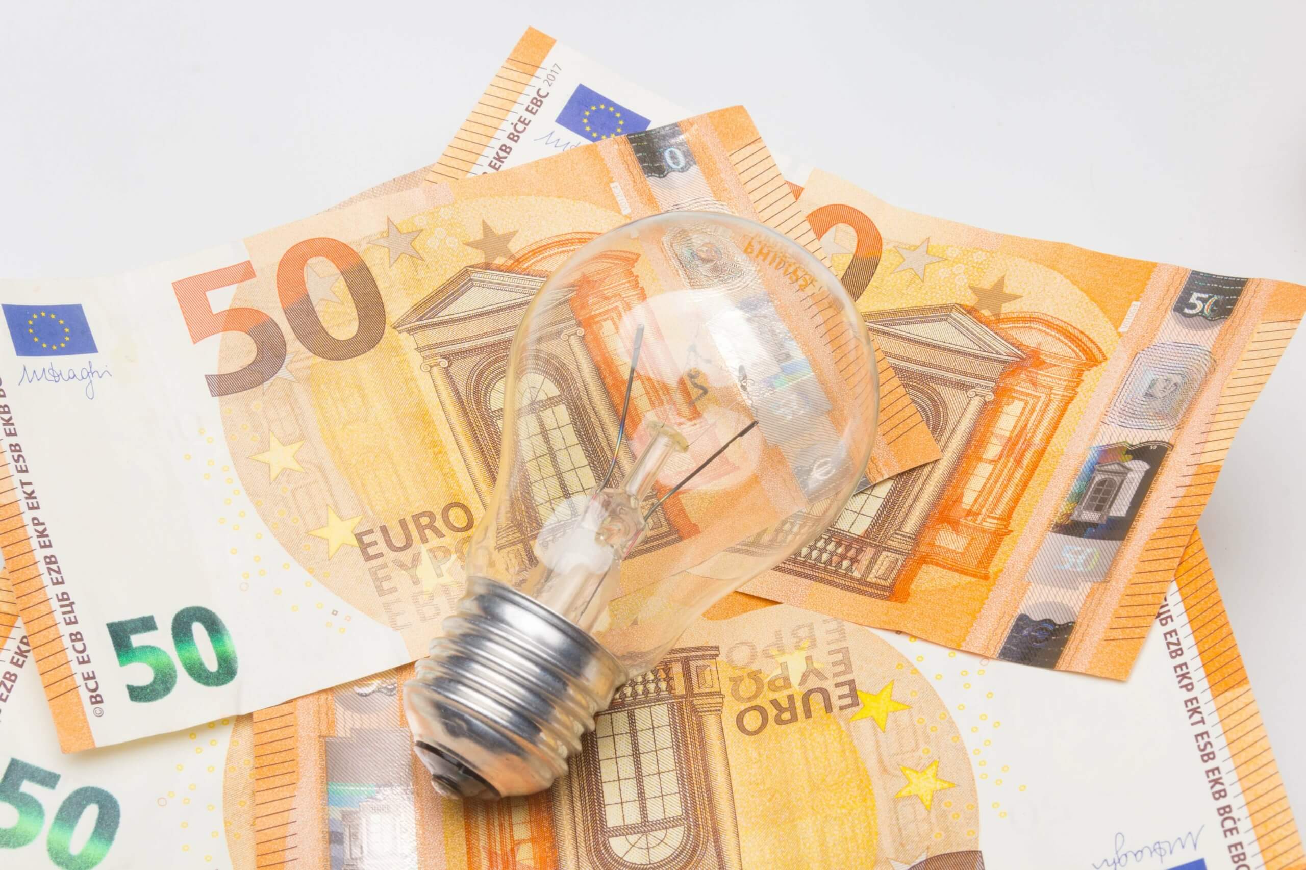 Glühbirne auf 50-Euro-Scheinen symbolisiert Kürzung der Fördermittel für Energieberatungen