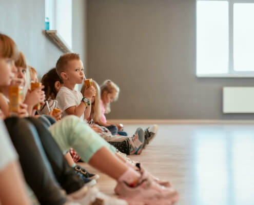 Gruppe von Kindern in einer Kita während der Pause, potenzieller Empfänger von Fördermitteln für energieeffiziente Umbauten.