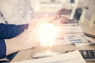 Energieeffizienz und Energiemanagement: Anforderungen des Energieeffizienzgesetzes bis 2025. Ein Arbeitsplatz mit Glühbirne als Symbol für Energieeffizienz und neuen gesetzlichen Vorgaben für Energiemanagementsysteme bis 2025.
