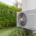 Moderne Wärmepumpe an der Außenwand eines Hauses, nachhaltige Heiztechnologie für die Wärmewende