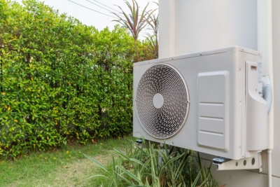 Moderne Wärmepumpe an der Außenwand eines Hauses, nachhaltige Heiztechnologie für die Wärmewende