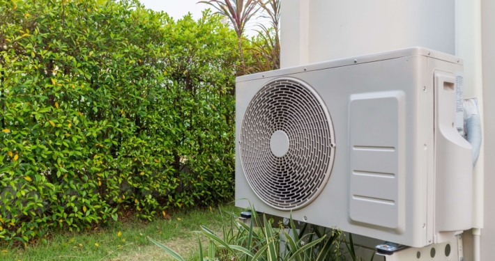 Moderne Wärmepumpe an der Außenwand eines Hauses, nachhaltige Heiztechnologie für die Wärmewende