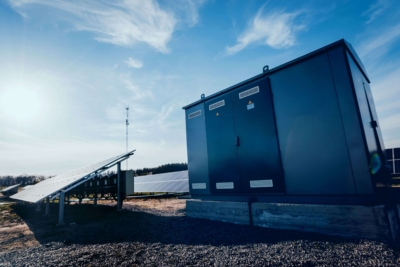 Zwei Handwerker montieren eine Wärmepumpe an einem Gewerbegebäude als Teil energieeffizienter Gebäudetechnik