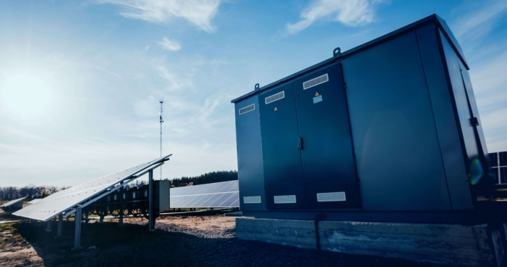 Zwei Handwerker montieren eine Wärmepumpe an einem Gewerbegebäude als Teil energieeffizienter Gebäudetechnik