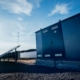 Zwei Handwerker montieren eine Wärmepumpe an einem Gewerbegebäude als Teil energieeffizienter Gebäudetechnik