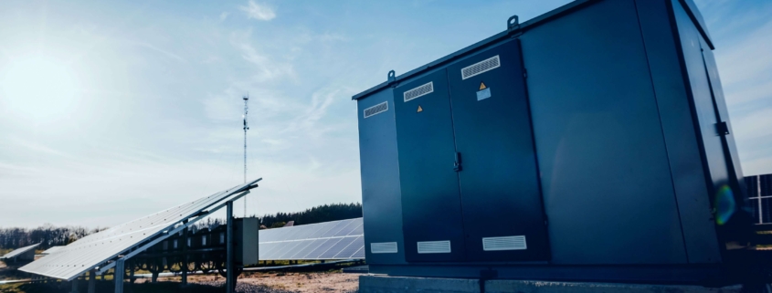 Zwei Handwerker montieren eine Wärmepumpe an einem Gewerbegebäude als Teil energieeffizienter Gebäudetechnik