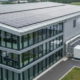 Gebäude eines mittelständischen Unternehmens mit Photovoltaik-Anlage auf dem Dach und technischer Energieinfrastruktur
