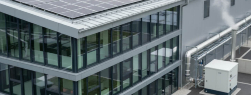 Gebäude eines mittelständischen Unternehmens mit Photovoltaik-Anlage auf dem Dach und technischer Energieinfrastruktur