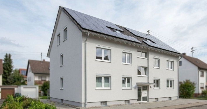 Beispiel für energetische Sanierung im Bestand: WEG-Wohnhaus mit neuen 3-fach verglasten Fenstern, Wärmedämmung und Solaranlage.