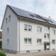 Beispiel für energetische Sanierung im Bestand: WEG-Wohnhaus mit neuen 3-fach verglasten Fenstern, Wärmedämmung und Solaranlage.