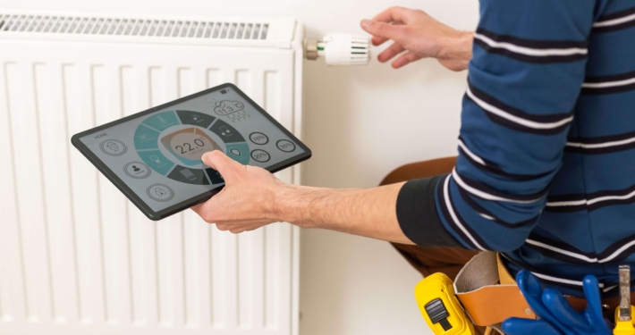 Digitale Heizungsoptimierung an einem Heizkörper mit smartem Thermostat und Tablet zur Energieüberwachung