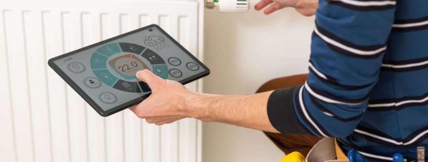 Digitale Heizungsoptimierung an einem Heizkörper mit smartem Thermostat und Tablet zur Energieüberwachung