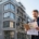 Energieberater prüft Modernisierungsunterlagen vor einem sanierten Mehrfamilienhaus mit Gerüst in einer deutschen Großstadt im Kontext der Mietrechtsreform 2026