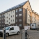 Geothermie-Bohrung neben modernisiertem Mehrfamilienhaus mit Photovoltaik und öffentlicher E-Ladestation in Nordrhein-Westfalen