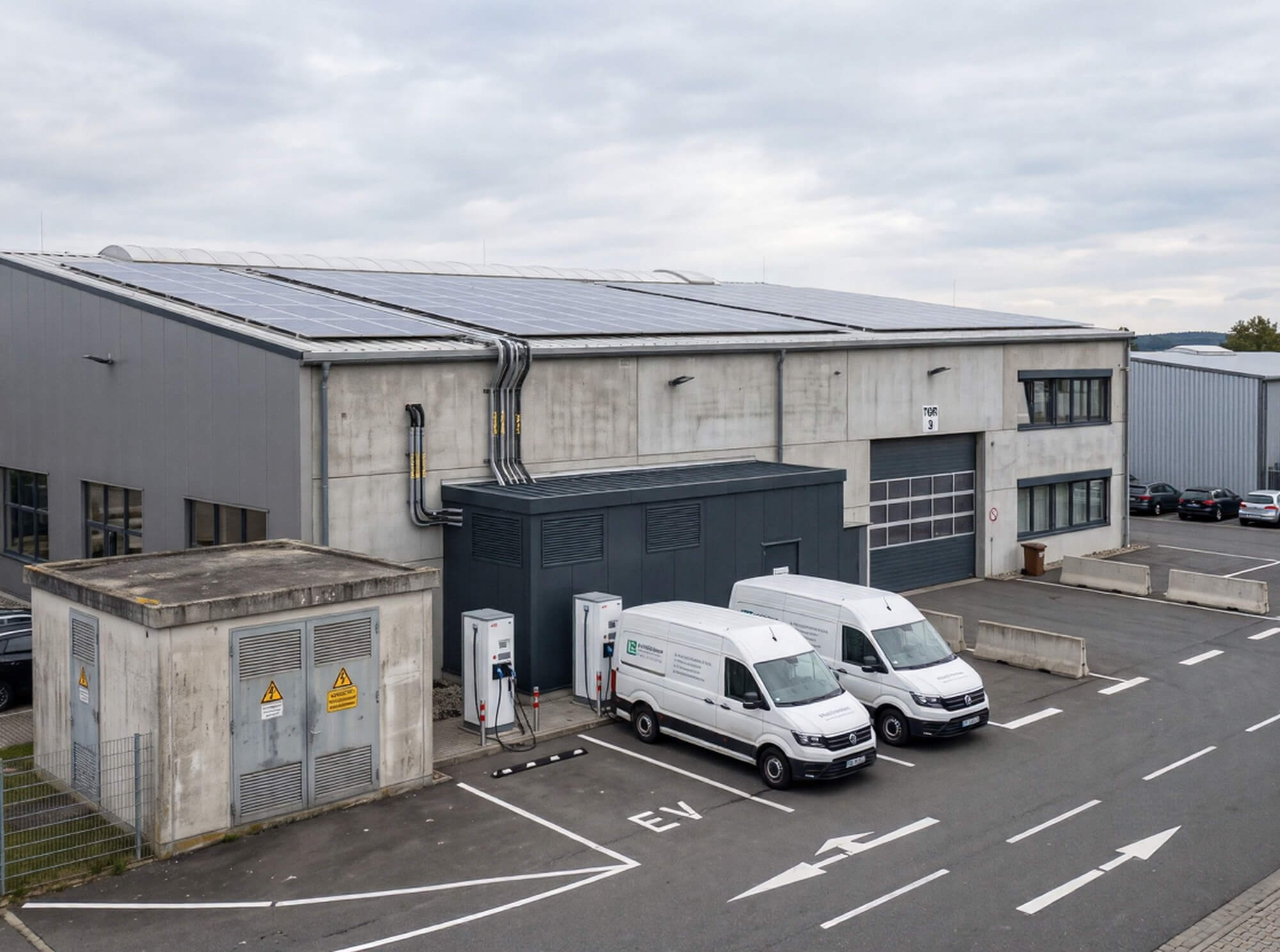 Industriegebäude mit Photovoltaikanlage, Trafostation und Ladesäulen als Beispiel für Elektrifizierung im Mittelstand