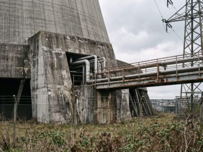 Kühlturm-Fuß und Rohrleitungen eines Kohlekraftwerks bei bedecktem Himmel