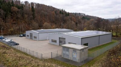Gewerbegebiet am Rand eines Thüringer Mittelgebirgstals mit Hallen, Photovoltaik und Umspannstation