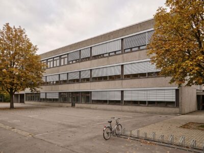 Südfassade eines Schulgebäudes der 1970er-Jahre mit neu montierten außenliegenden Raffstores