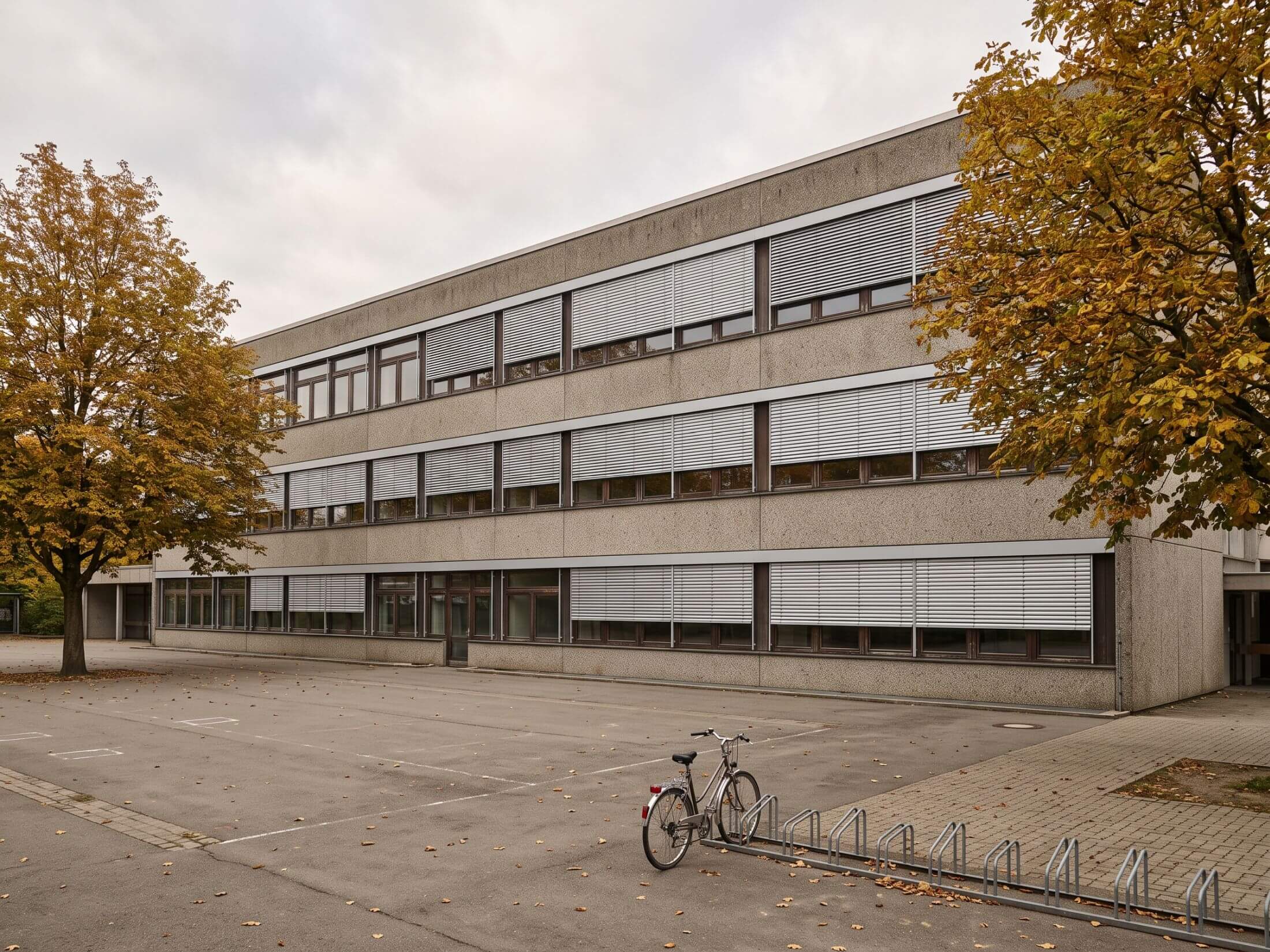 Südfassade eines Schulgebäudes der 1970er-Jahre mit neu montierten außenliegenden Raffstores