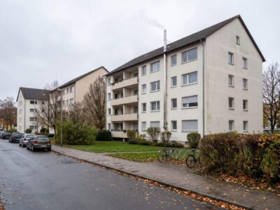 Wohnanlage aus drei Mehrfamilienhäusern mit Schornstein der Gaszentralheizung im Spätherbst