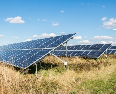 Solaranlagen und Windrad als Symbol für die fortschreitende Energiewende in Deutschland 2023