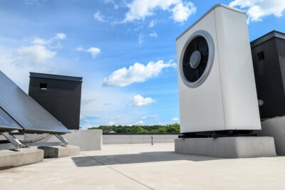 Kombination von Wärmepumpe und Solarkollektor auf einem Hausdach, repräsentativ für die Förderung erneuerbarer Energien in Deutschland ab 2024
