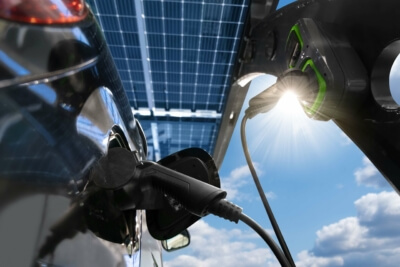Elektroauto wird an Solar-betriebene Wallbox geladen, unterstützt durch KfW 442 Förderprogramm für 2024